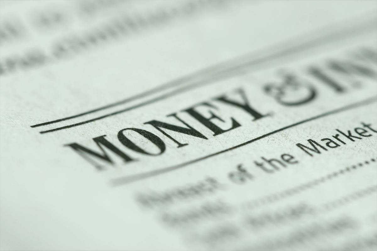 A dramatic macro close-up of currency paper texture with shallow depth of field, highlighting detailed green security engraving lines and currency print.
